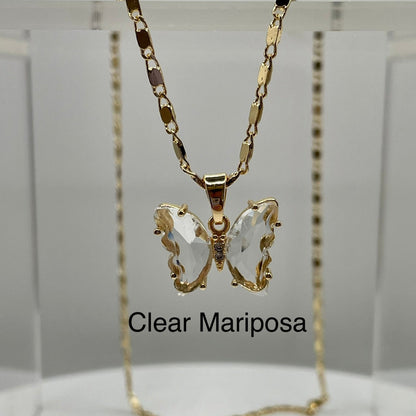 Clear butterfly pendant on gold necklace displayed on an acrylic base. Butterfly pendant. iridescent butterfly pendant. Mariposa pendant. Gold plated pendants.