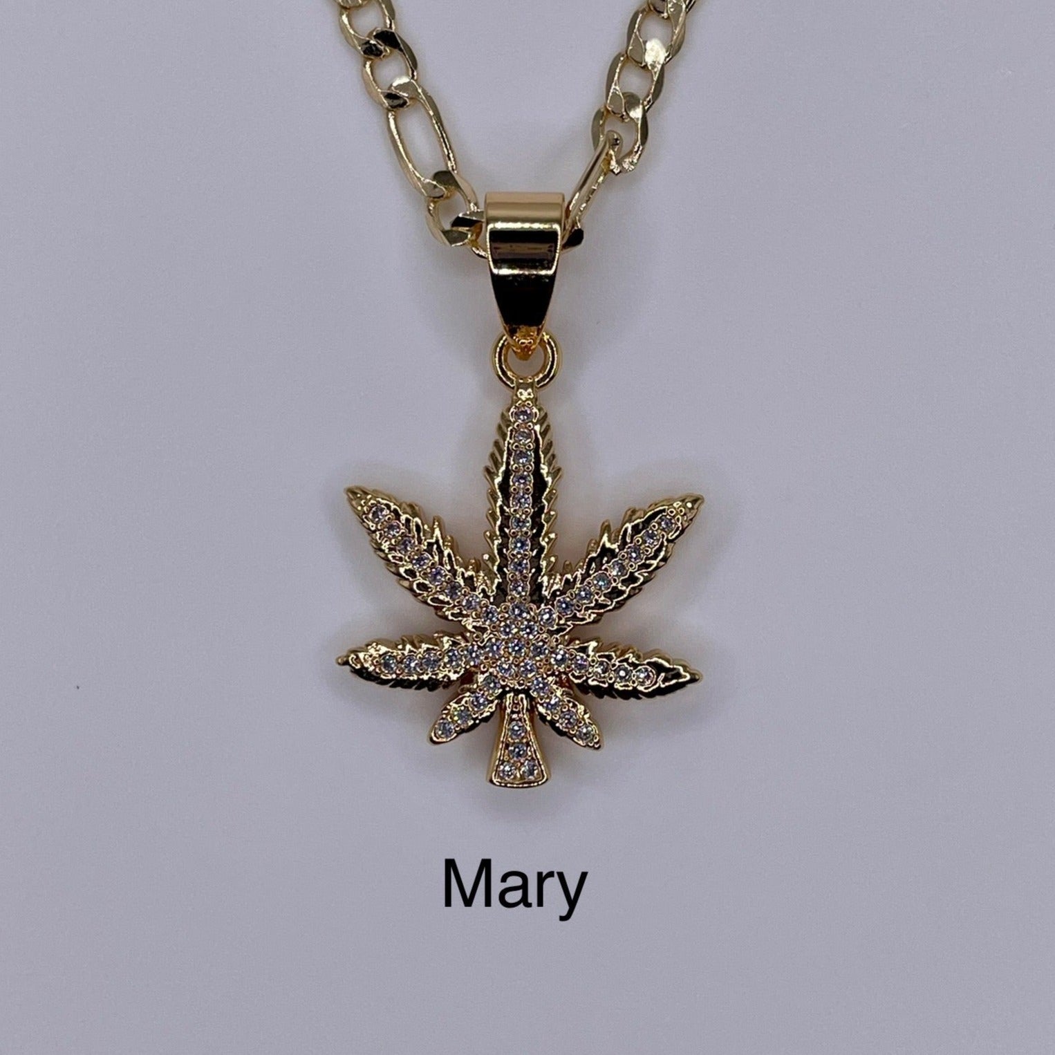Marijuana gold plated pendant being displayed. Marihuana pendant.